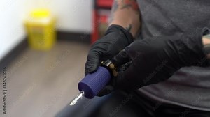 Female tattooist setting up the tattoo machine.