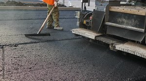An asphalt spreader or an asphalt paver machine on a road construction site. Road repairs. Stock Video