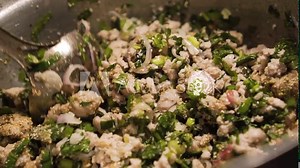 Someone strirring up a minced pork in a pot. Making of Larb. Spicy pork Thai salad. Isaan menu. Slow motion