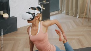 Athletic young woman practicing yoga on mat meditation wearing virtual reality headset, vr yoga. Modern technology augmented reality and mindfulness concept, metaverse headset, stretching at home