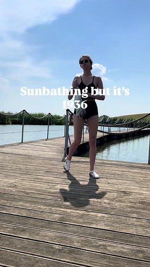 Vintage swimsuit try-on at lakeside wooden bridge