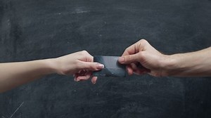 Cashless transfer. Man hand giving credit card to woman over blackboard.