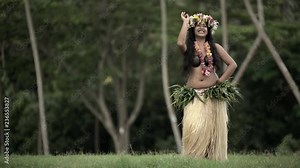 Young Polynesian Tahitian female hula dancer in grass skirt performing outdoor barefoot in traditional costume Tahiti French Polynesia South Pacific
