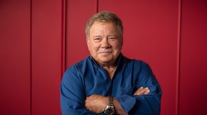 Icon William Shatner gives Debbe Dunning a ride on his lap in mobility scooter