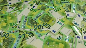 Euro banknotes falling on the table with a lot of money.