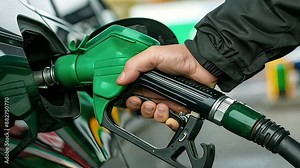 man pumping gasoline fuel in car at gas station
