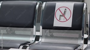Empty hospital reception chairs with covid 19 safety prevention in waiting area. No people attending checkup visit and examination with medical staff, waiting room lobby at clinic. Close up.