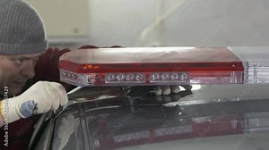 Emergency vehicle lighting installation. Mounting police red blue emergency LED light bar on top of the car. Stock Video
