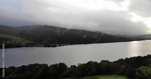 panning right shot revealing the length of Loch Tummel in the Scottish Highlands with the sun streaming through the clouds