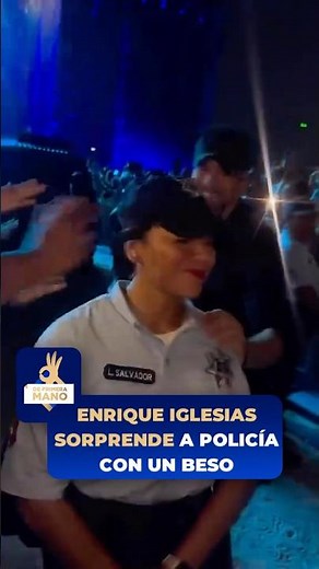 Enrique Iglesias surprises a police officer with a kiss.