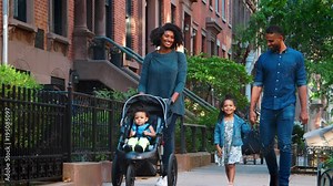 Young black family with stroller walking in Brooklyn street