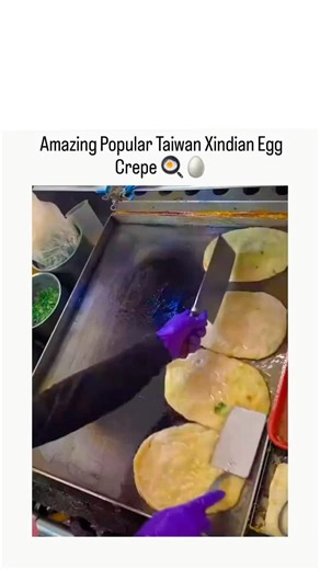 Meme Flix on Instagram: "a street vendor in Taiwan crafting dan bing (egg crepes) from Xindian, starting with thin batter on a griddle, pouring whisked eggs, flipping for crisp edges, and rolling into portable treats, emphasizing the hands-on, sizzling process. within a day, tapping into ASMR-style cooking trends that boost engagement on X for global audiences craving authentic street eats. Xindian dan bing, a savory twist on traditional dan bing with green onions and optional cheese, stems from