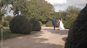 Anonymous bride and groom walking away from camera 4K