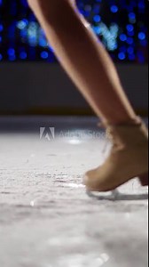 Dancing on ice, pro gymnast performs a trick on ice, woman spinning on skates, a view of the legs, vertical video.