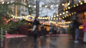 Time lapse. A branch of a Christmas tree with people shopping at the market in the background.