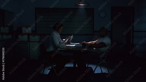 Criminal in handcuffs being interrogated by female police detective