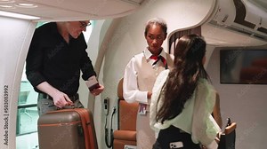 Two beautiful Asian female flight attendants welcome and inspect boarding pass their passengers