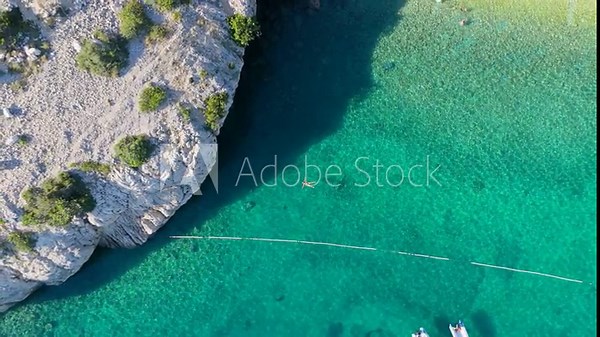 Beautiful Young Woman in Bikini Swims in Stara Baska Beach Krk Island, Croatia. Mediterranean Summer. Aerial Shot From Above. Blue Sea the Rocks Mountains and Coastline Calm Sea With Clear Blue Water