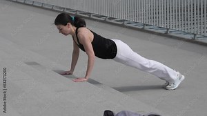 n the midst of a challenging workout, this woman's push-up stance highlights her fitness level and the beauty of exercising outdoors.
