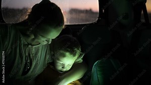 Mother and son using touch pad in car at night Stock Video