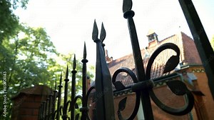Church, iron fence with sharp-pointed spikes in the light of sunlight