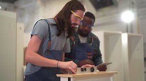 Professional carpenters using a ruler and spirit level to measures a wood panel. Professional carpenter measuring a wood plank.