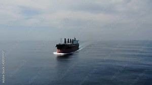 Large cargo ship. A bulk carrier carries cargo across the ocean. Transportation. Delivery. Logistics. A large ship for transporting. Aerial 4k shot.
