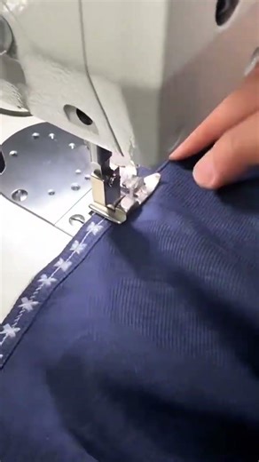 sewing white star patterns on dark blue fabric using a professional industrial sewing machine shop