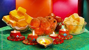 Colorful Diwali oil lamps, Deepavali oil lamps lighted in beautiful formation with bowls full of different Diwali sweets. Decorative Colorful Diya lamps lit during Diwali celebration