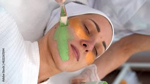 The cosmetologist applies a mask to the client face, makes procedures in the spa or salon close-up. Skin care, cosmetology and beauty. 4k vertical video