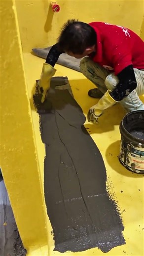 applying of a cement mixture to the yellow floor using a trowel for neat and clean result