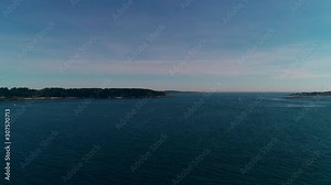 Slow aerial pull back over an inlet near Casco Bay toward a distant sailboat on Chebeague Island Maine