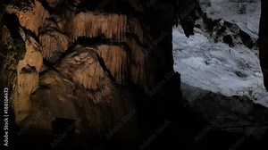 Ancient formations of stalactites and stalagmites slow tilt footage - Area deep inside underground cavern
