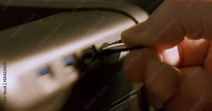 The hand of a Caucasian male removing a memory card from the designated reader slot in the computer . Macro Shot, Extreme shallow DOF