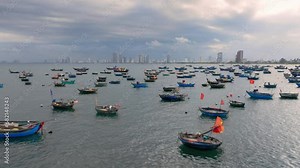 Traditional Coracle Fishing Boats of Vietnam. Aerial Tilt Up to Reveal City Skyline
