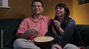 Young couple watching a movie at home