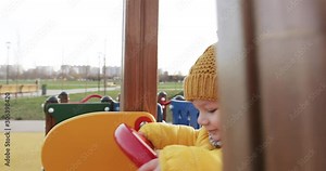 Baby rides a slide on a playground