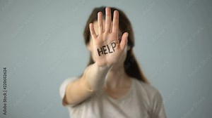 Bruised female with help inscription on hand, assault, cruel treatment of women