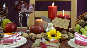 Traditional Thanksgiving table with place settings and cornucopia centerpiece in colorful rustic style, dolly slow left closeup.