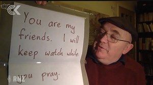 An image of Manchester man Andrew Graystone standing outside a local mosque holding a sign saying he'll keep watch while Muslims pray, has gone viral. He told Checkpoint he just wanted to make people feel they were among friends instead of enemies. | Checkpoint