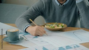 Businessman talking on phone, correcting financial graphs and getting food in modern cafe. Concept of: business peope, cafe table, modern interior, charts and graphs, financial planning, delicious Stock Video