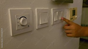 Finger switching on light switch. Power, energy and electricity consumption at home.