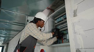 Electrician installing surge protector in electrical panel