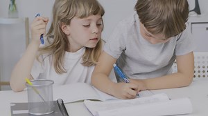 Download Brother helps his younger sister to make her homework for free