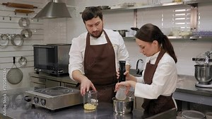 The pastry chef whips up the nutmeg glaze in a blender for a mousse cake in a professional kitchen.