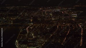 AERIAL HELI SHOT, ESTABLISHING SHOT: Flying above New York City Williamsburg Bridge, East Village and Little Germany neighborhood looking towards Brooklyn borough and Staten Island lit up at night