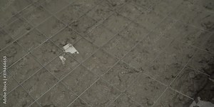 The metal mesh is laid on the floor. The process of leveling the floor. The metal mesh is placed on a fresh solution. Lay the steel rod in the form of a mesh for cement work when pouring the floor. A