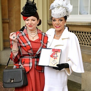 Joan Collins, 81, Becomes a Dame and Rocks Regal Look at Palace, Celebrates With Family and Delicious Treat—See Pics!