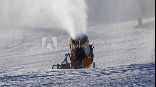 4K video of a snow gun or snow cannon producing snow through the snowmaking process. Filmed in winter at the outdoor ski resort slopes.