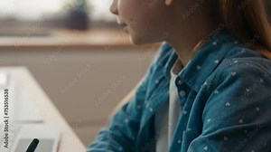 Moving camera little school girl studying at kitchen with laptop writing homework copybook. Child daughter kid schoolgirl pupil write math language exercise distance learning home education e-learning